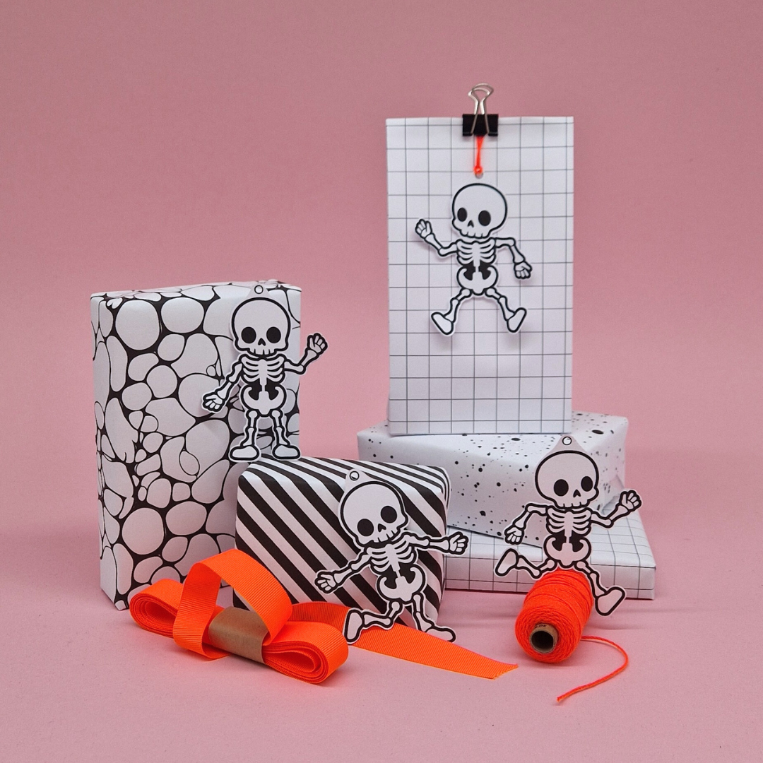 Decorative skeleton gift tags with skeleton designs on a pink background