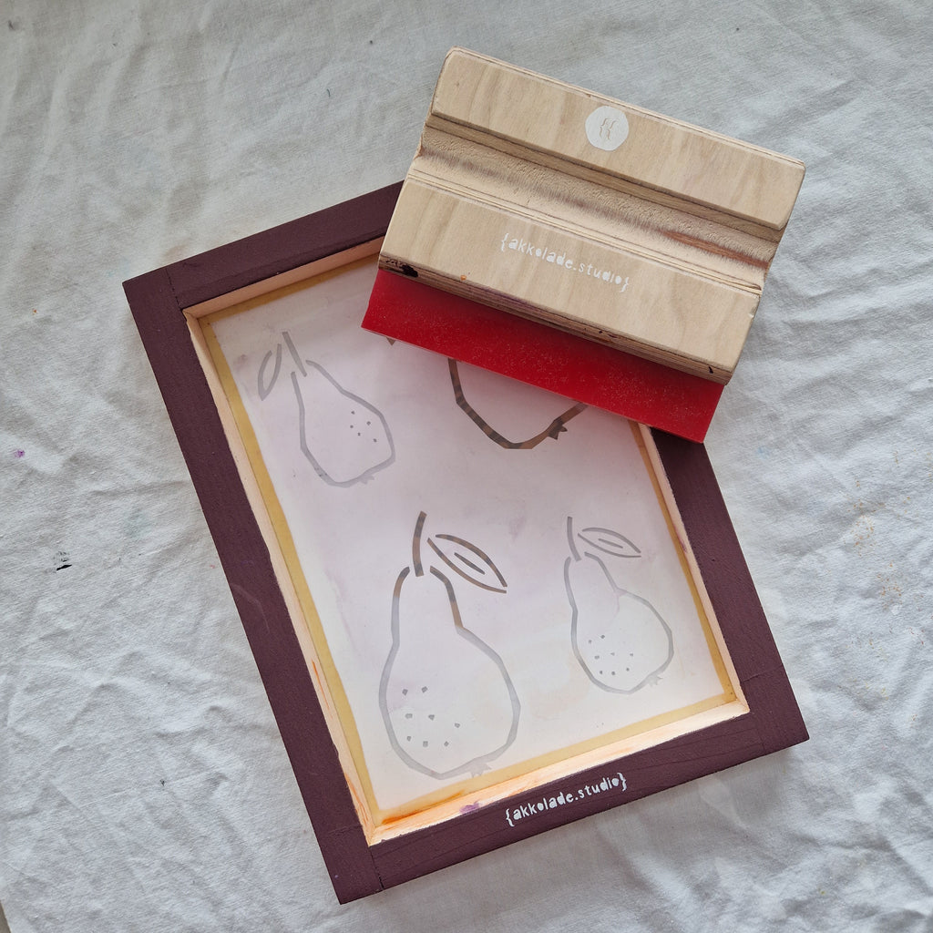 screenprinting frame and squeegue with pear stencil on white background