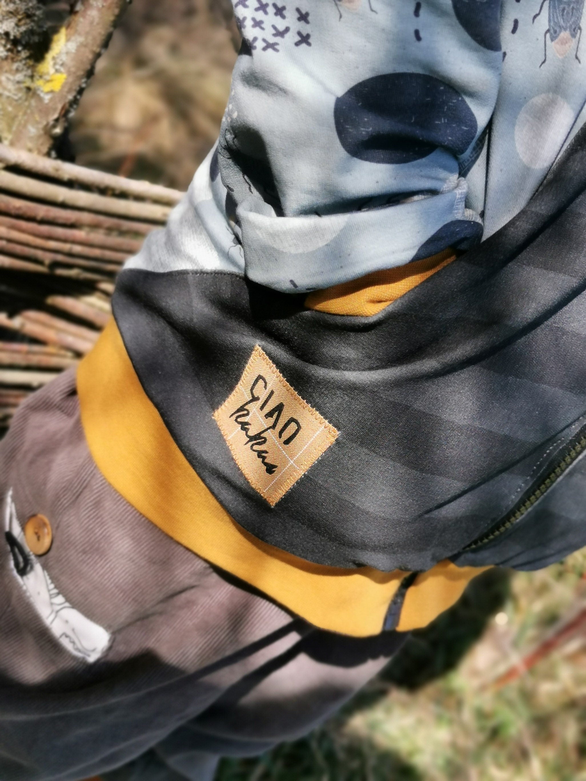 Close-up of a child's jacket with a ciao kakao label, outdoors.